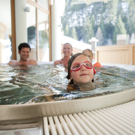 Familie beim Schwimmen und Tauchen im Hallenbad