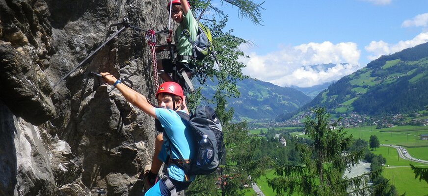 Kinder beim Klettern am Fels