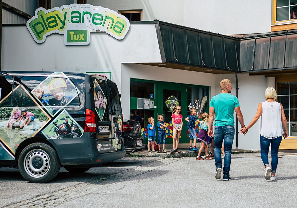 Familie geht auf den Eingang Playarena zu