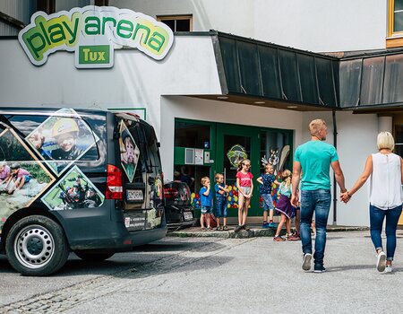 Familie geht auf den Eingang Playarena zu