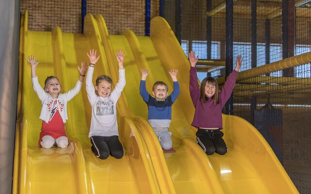 Kinder rutschen auf der Wellenrutsche