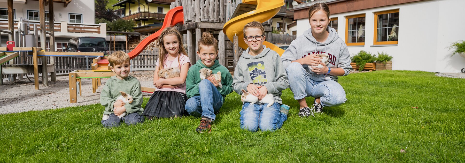 Kinder am Spielplatz mit Kaninchen