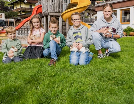 Kinder am Spielplatz mit Kaninchen